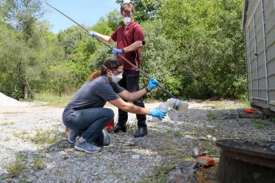 Amy Pruden and a student outdoors transferring water samples as part of the Pruden Lab's Antibiotic Resistance Research.